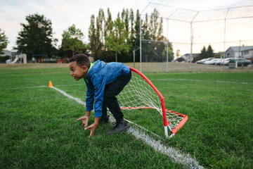 Little boy having fun learning soccer skills outside