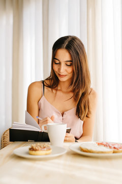 Woman having breakfast and writing