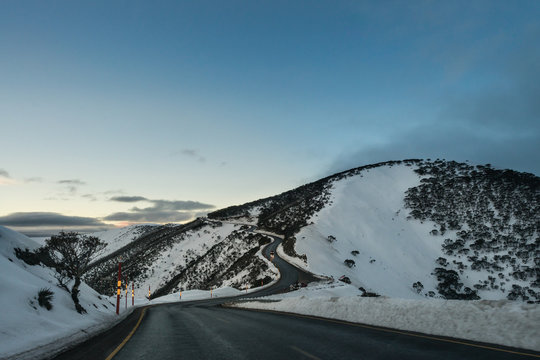 road running along snow covered mountains