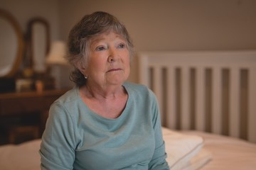 Worried senior woman sitting on the bed