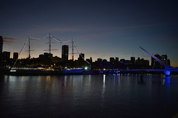 harbour with sailing boat and skyline of Puerto Madero at night with woman's bridge, or puente de la mujer, Buenos Aires, Argentina