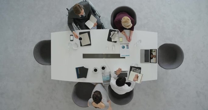 professional business team having conference call in boardroom meeting brainstorming corporate leadership sharing strategy using laptop above view