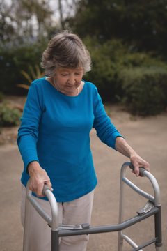 Senior woman walking with the help of walker