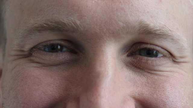 close up happy man blue eyes looking at blinking smiling caucasian male healthy eyesight ocular sense