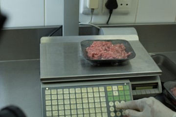 Butcher checking weight of packed meat
