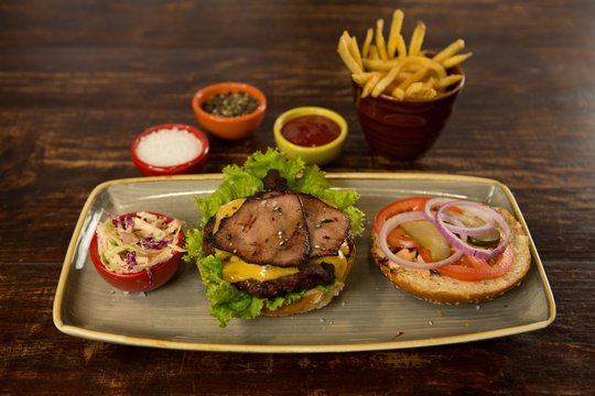 Meat burger with french fries on wooden table