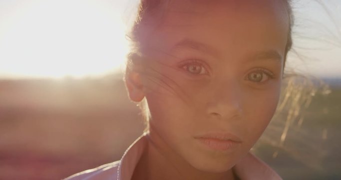 close up portrait young little mixed race girl looking serious contemplative kid on sunny park sunset slow motion
