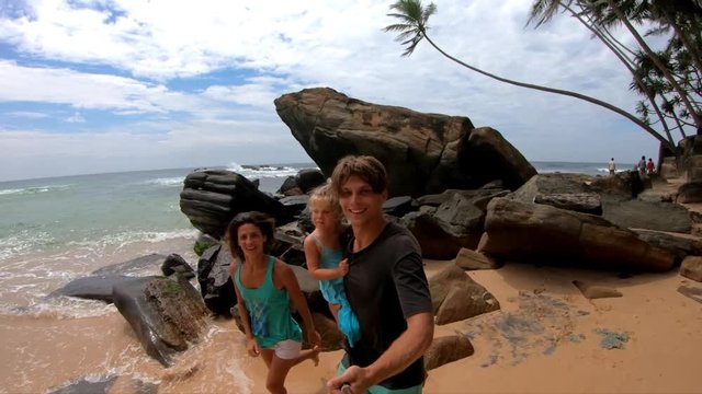 Family have fun on the rocky beach at sunny day make video gopro slow motion