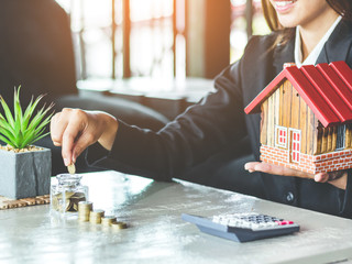 Business woman saving money for buy a new house to family in the future concept.