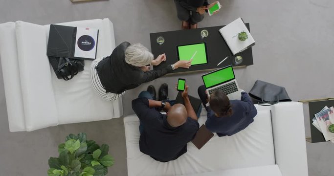 professional business people brainstorming innovative ideas for startup company viewing green screen using mobile computer technology in office lobby meeting above view