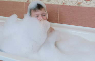 Boy 6-7 years prepare to dive into a bubble bath, eyes closed.