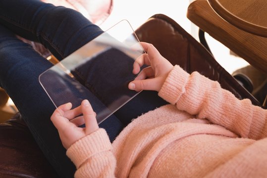 Girl using glass digital tablet in living room