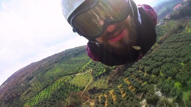 The largest zipline in Europe. Young man with a sports helmet on the head with camera sliding on zip line in summer day in Italy.