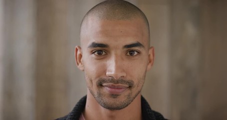 close up portrait of attractive young hispanic man smiling enjoying happy lifestyle looking at camera wooden background slow motion - Powered by Adobe