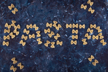 Pasta laid out in the form of an inscription on a blue textured background.