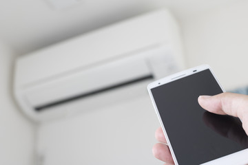 スマートフォンでエアコンを操作するイメージ
