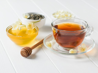 Honey, herbal tea and jasmine on a white wooden table. A set of natural products for the treatment of many diseases.