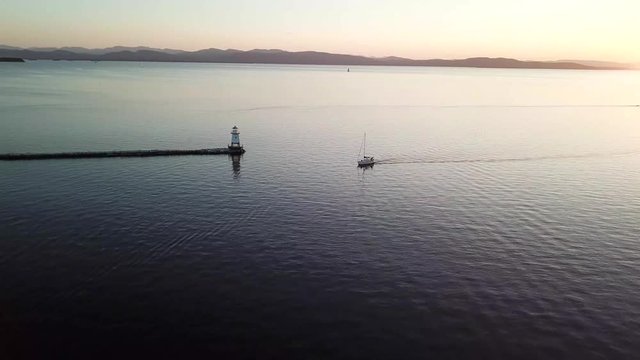 Sailing Towards A Light House In Burlington, Vermont, On The Waterfront.