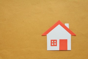 Paper cut of house red roof on brown background,top view. 