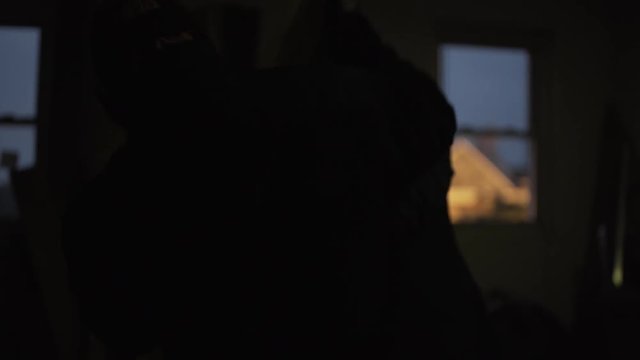 3 men getting into a scuffle in a dark room.