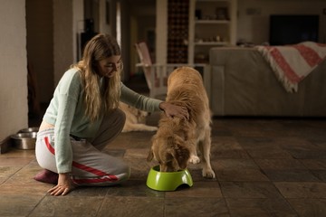 Girl feeding her dog at home