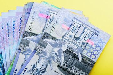 Tenge. Kazakh banknotes on a yellow background close-up..