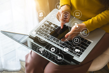 top view of woman hand using smart phone,mobile payments online shopping,omni channel,digital tablet docking keyboard computer in modern office on white desk,virtual interface icons screen