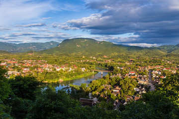 View of Luang Prabang and Nam Khan river in Laos with beautiful sunset light bathing the city