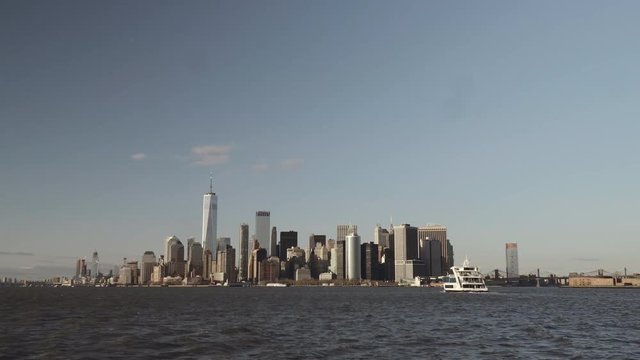 Wide shot of financial skyscrapers in downtown New York in Lower Manhattan filmed from the south river in late afternoon