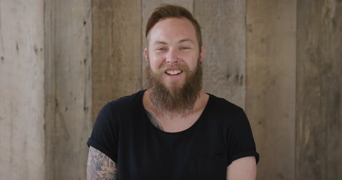 young hipster punk man with beard laughing cheerful enjoying successful lifestyle handsome independent male tattoo 