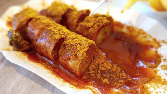 Eating popular German currywurst sausage Close up Shallow DOF