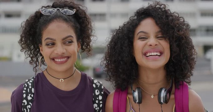 portrait beautiful young hispanic twin sisters smiling together happy female siblings enjoying vacation lifestyle in urban city looking stylish real people series