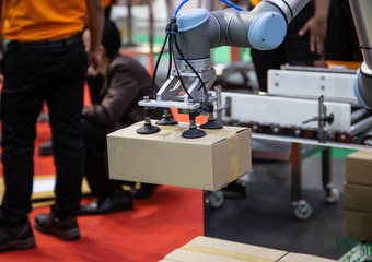 The universal robot vacuum lifting cardboard in production line. Industrial logistics warehouse