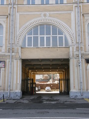 yellow old house with windows and a long arch through the courtyard