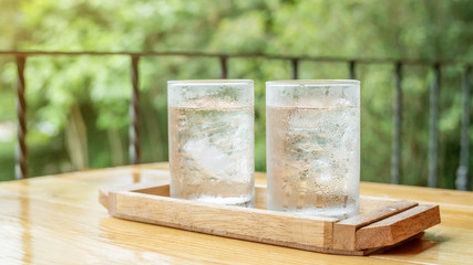 A glass of drinking water on a wooden table.