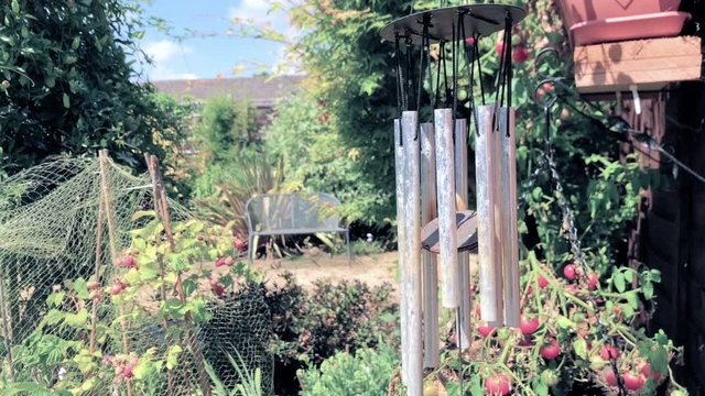 Wind chimes blowing in the wind in a garden in England on a warm summers day