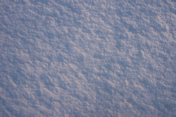 The texture of the snow surface illuminated by the evening sun. Background