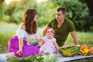 Family on an outdoor picnic with a cute little daughter