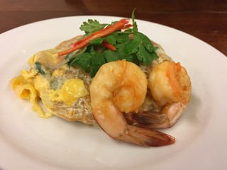 Top view of a Shrimp Pad Thai, traditional Thai dish with stir fried rice noodles with big shrimps, you can try to eat Pad Thai on the street in Bangkok, Thailand, Street food of Bangkok, Thailand