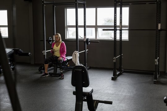 Mature woman using mobile phone in the gym
