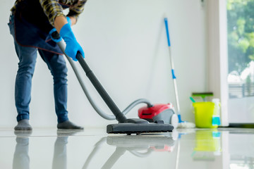 Cleaning Service concept. Cleaners employee removing dirt with equipment in office.