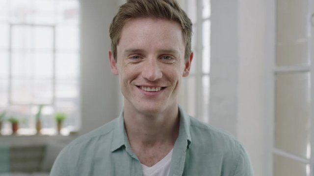 young handsome man portrait of red head guy smiling cheerful enjoying lifestyle change successful male in apartment background