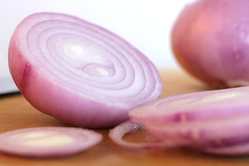 Obraz na płótnie Canvas Red onion slices on wooden cutting board