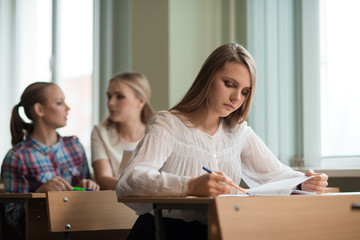 student girls are sitting at a Desk