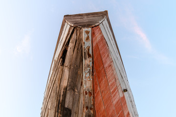 The stern of an old wooden boat in white and red colors