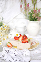 classic cheesecake with strawberries. On the table in the decor with wildflowers and daisies. bright colors