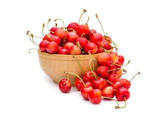 Wooden bowl with cherries on white background.