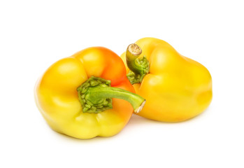 Two yellow sweet peppers on white.