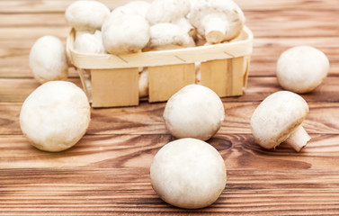 Champignons in wooden box on wooden background. Toned image.