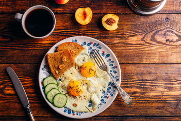Breakfast toast with fried eggs with vegetables on plate and cup of coffee with fruits over dark wooden background, top view. Healthy food concept.